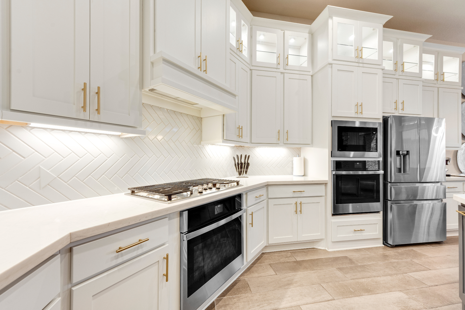 A modern kitchen featuring a stainless steel refrigerator and oven, showcasing a clean and organized space.