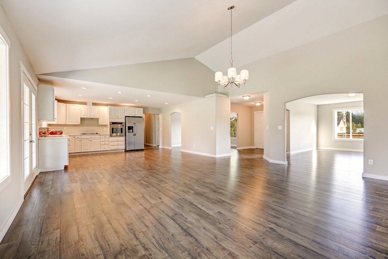 A spacious living room featuring hardwood floors and ample natural light, creating a warm and inviting atmosphere.