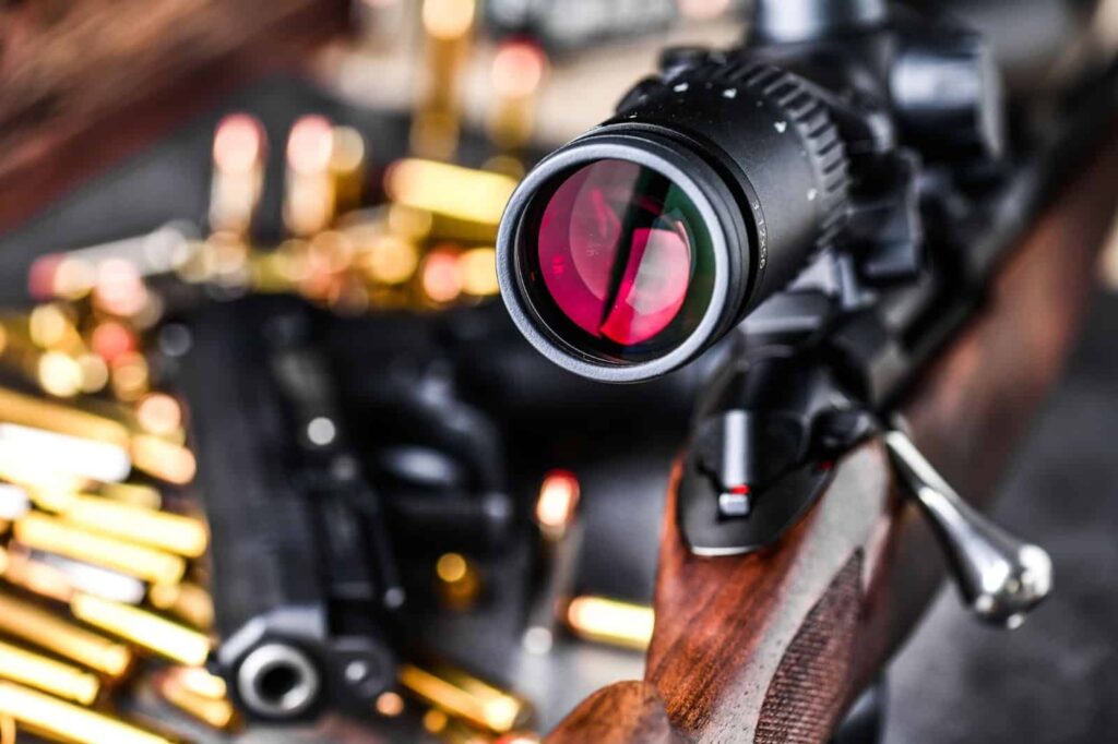 A rifle scope and gun placed on a table
